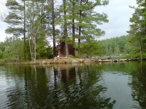 An outhouse located on it's own tiny island...
