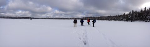 Snowshoeing crossing the lake. 